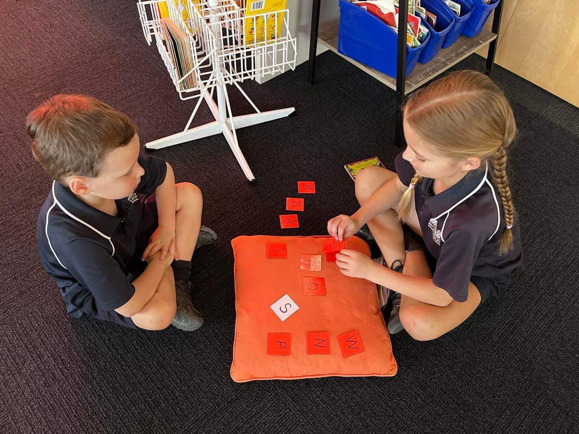 photo of a grade 6 student working with a Foundation student